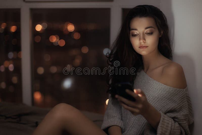 Kvinnabruk av mobiltelefonen inomhus p? natten royaltyfri bild Kvinnabruk av mobiltelefonen inomhus p? natten royaltyfri bild