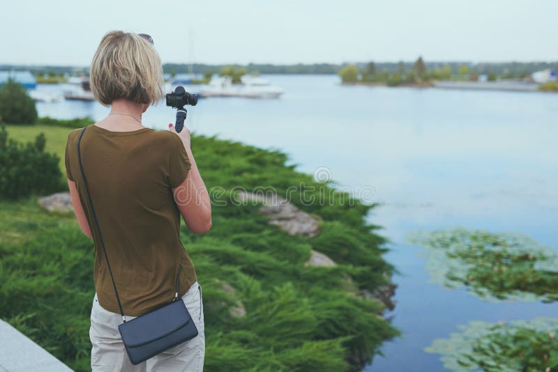 Kvinnafilmande med den lilla personliga kameran arkivfoto
