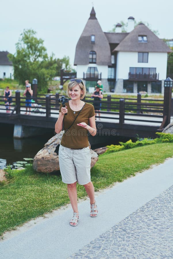 Kvinnafilmande med den lilla personliga kameran arkivfoto