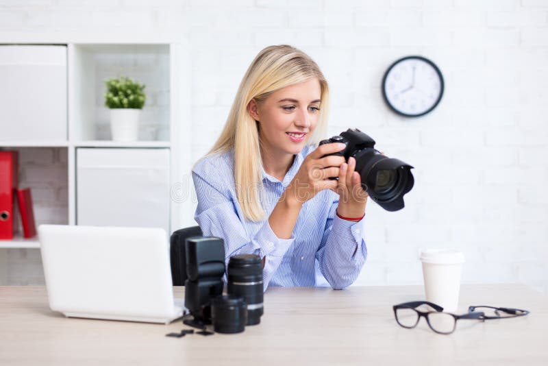 Kvinnafotografsammanträde med datoren och fotografiequipme royaltyfri fotografi Kvinnafotografsammanträde med datoren och fotografiequipme royaltyfri fotografi