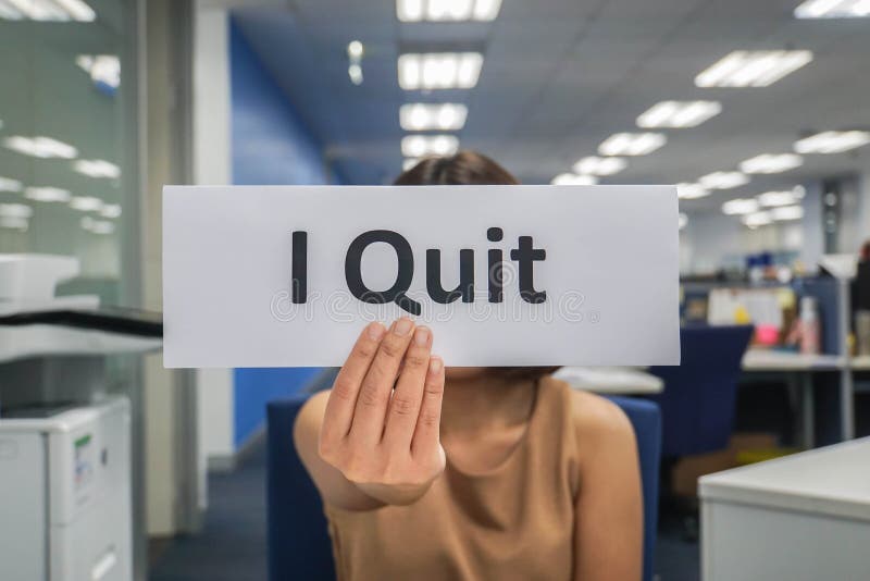 Business concept - woman hold paper of I quit in office. Business concept - woman hold paper of I quit in office