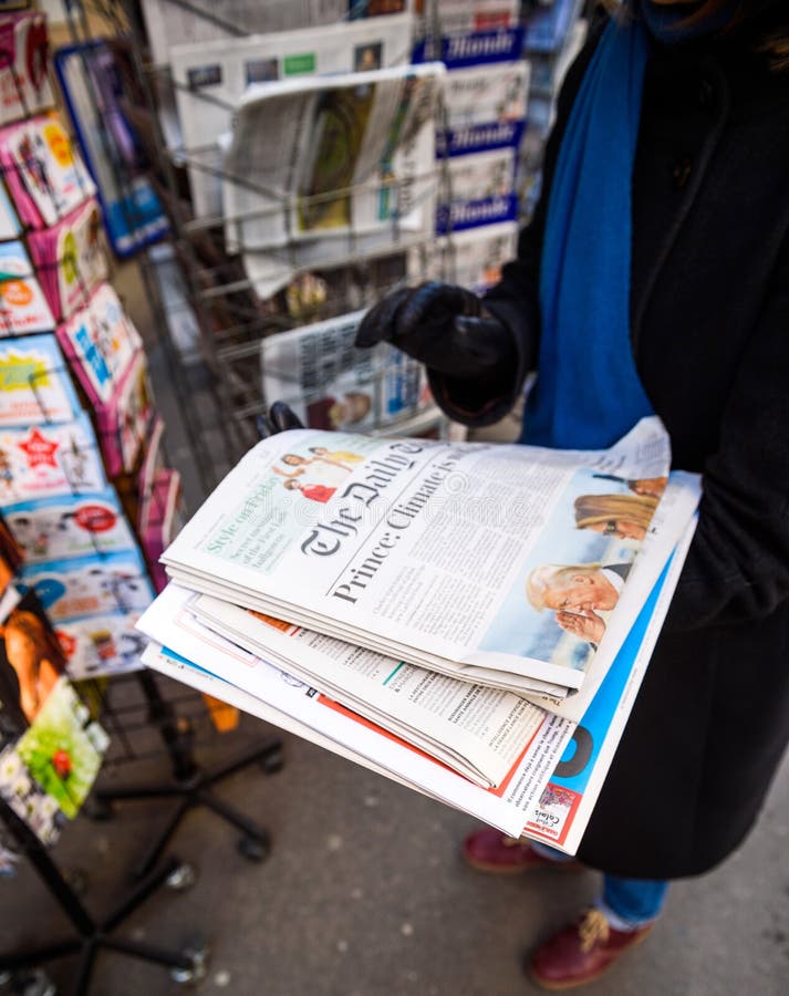 Kvinnan inhandlar den aTheDaily Telegraph tidningen från en tidningskiosk royaltyfri foto Kvinnan inhandlar den aTheDaily Telegraph tidningen från en tidningskiosk royaltyfri foto