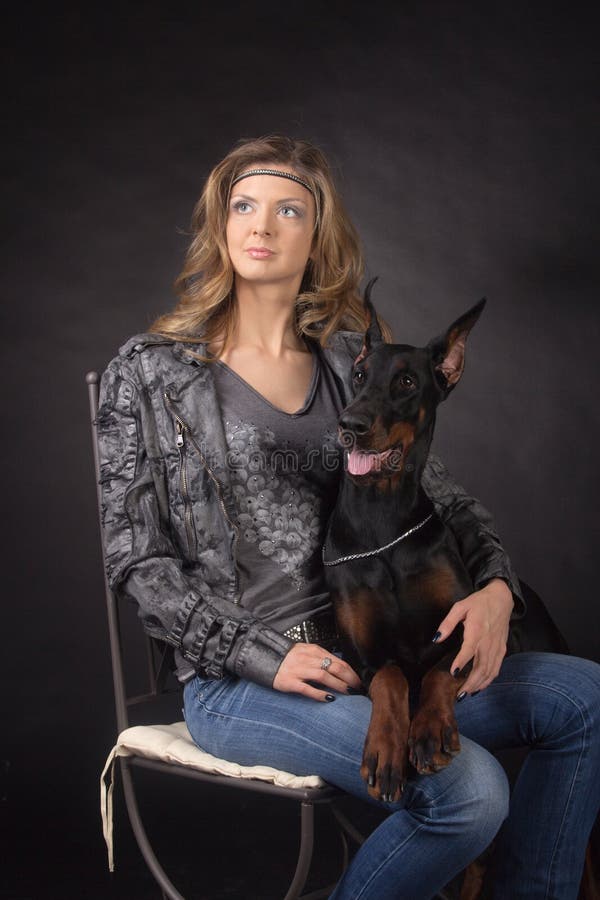 Kvinnan med dobermann förföljer arkivbild Kvinnan med dobermann förföljer arkivbild