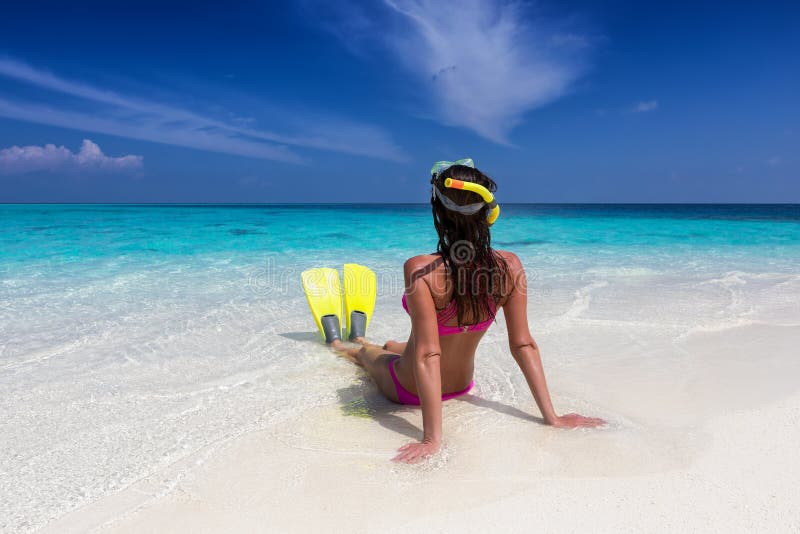 Kvinnan med fena och maskeringen för att snorkla sitter på stranden arkivfoton Kvinnan med fena och maskeringen för att snorkla sitter på stranden arkivfoton