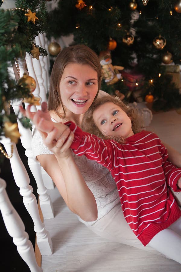 Kvinnan och flickan hänger stjärnan på julgirlanden arkivfoton Kvinnan och flickan hänger stjärnan på julgirlanden arkivfoton