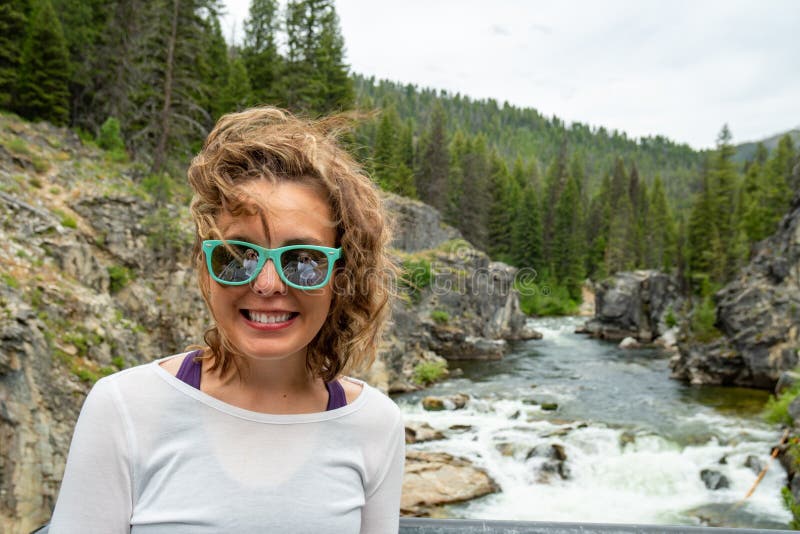 Kvinnan poserar vid den Dagger Falls vattenfallet i Idaho i lax-Challisnationalskogen royaltyfria bilder Kvinnan poserar vid den Dagger Falls vattenfallet i Idaho i lax-Challisnationalskogen royaltyfria bilder