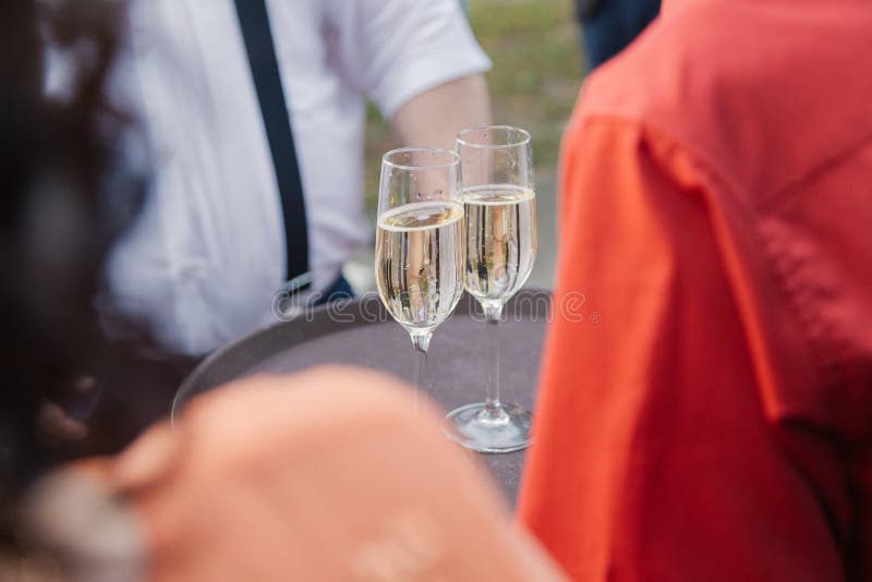 Kvinnan rymmer två exponeringsglas av champagne på ett magasin arkivfoton Kvinnan rymmer två exponeringsglas av champagne på ett magasin arkivfoton