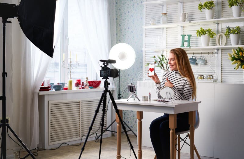 Kvinnan som filmar skönhet frågar efter gillar tummen på kameran. Inflytelserika blondinska flickan live royaltyfria bilder