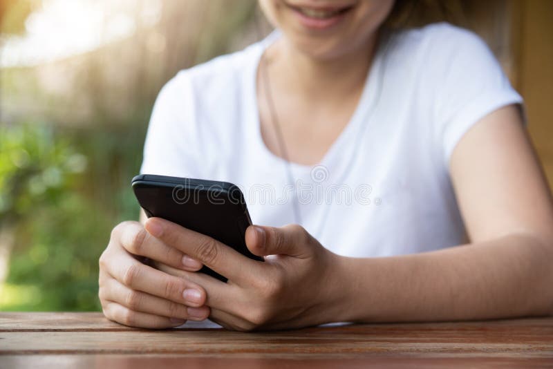 Kvinnan som lyssnar till musiken med headphonen och, ilar telefonen arkivbild Kvinnan som lyssnar till musiken med headphonen och, ilar telefonen arkivbild