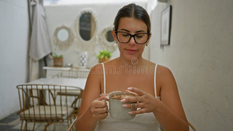 Kvinnan som njuter av kaffet inomhus vid ett matsalsbord med rustik dekoration och naturligt ljus arkivfoton