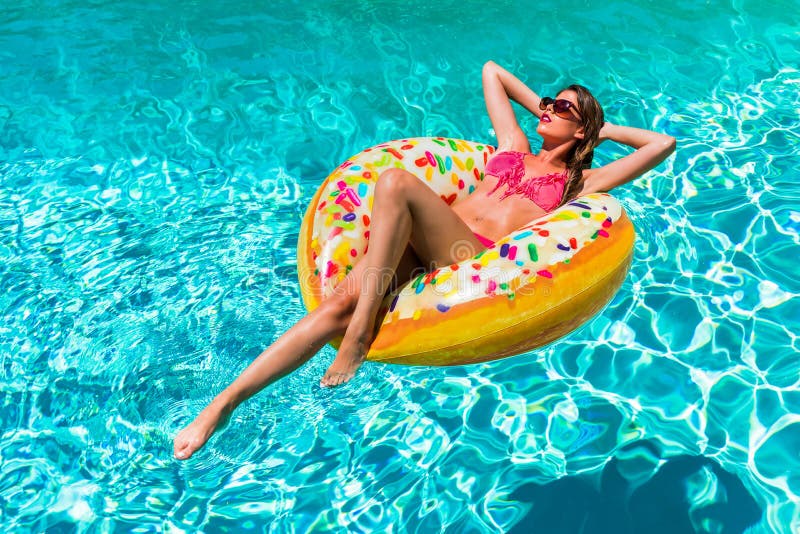 Kvinnan tar en sunbath i munken formad pölflöte på en varm sommardag royaltyfri fotografi Kvinnan tar en sunbath i munken formad pölflöte på en varm sommardag royaltyfri fotografi