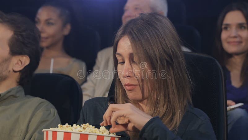 Kvinnan äter popcorn på filmbiografen
