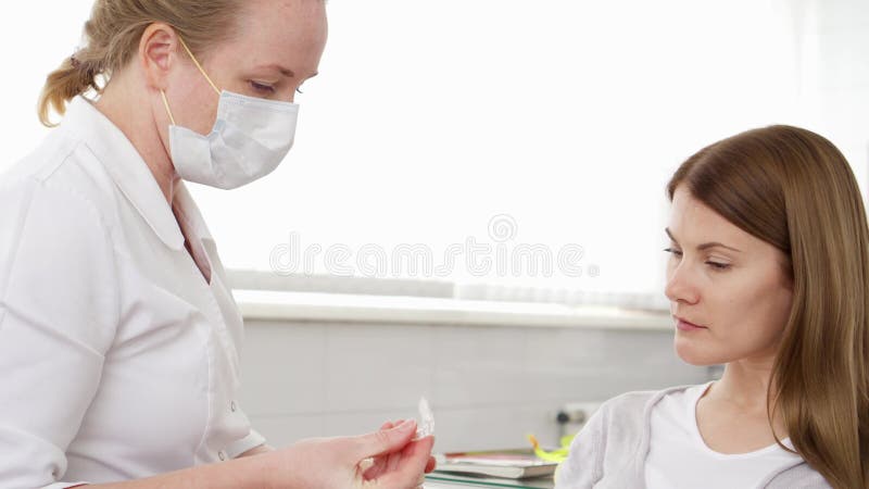 Kvinnatandläkare som talar med den kvinnliga patienten i klinik Kvinnlig yrkesmässig doktor på arbete Tand- kontroll upp