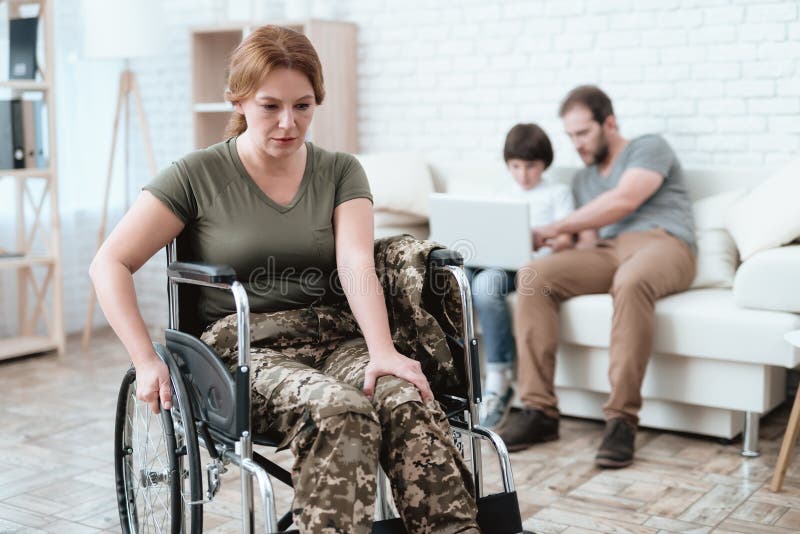 Kvinnaveteran i rullstolen som gås tillbaka från armén En kvinna i en rullstol är smärtar in Henne ` s i militär likformig royaltyfri foto Kvinnaveteran i rullstolen som gås tillbaka från armén En kvinna i en rullstol är smärtar in Henne ` s i militär likformig royaltyfri foto