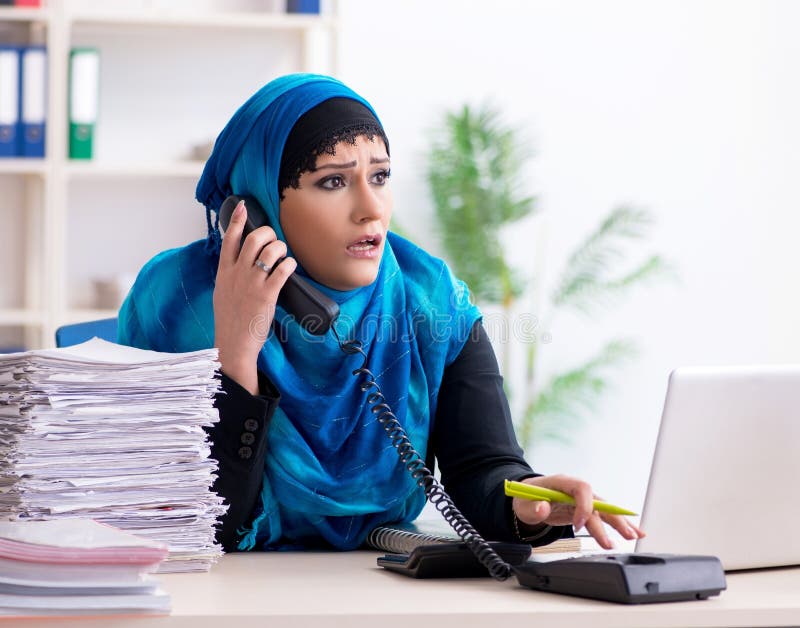 Kvinnlig anställd i hijab som arbetar på kontoret arkivfoto