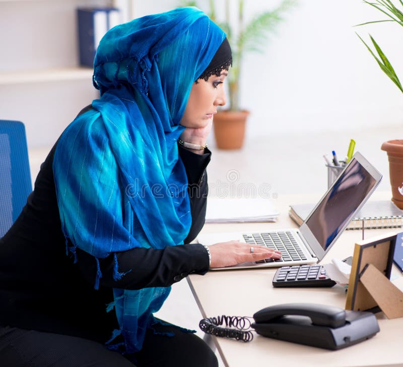 Kvinnlig anställd i hijab som arbetar på kontoret arkivfoton