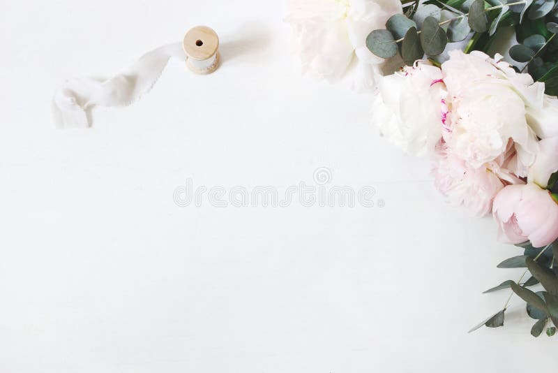 Kvinnlig bröllop- eller födelsedagtabellsammansättning med den blom- buketten Vita och rosa pionblommor, eukalyptus och silke royaltyfri fotografi