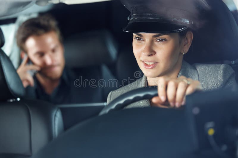 Kvinnlig chaufför som kör en limousine royaltyfri fotografi Kvinnlig chaufför som kör en limousine royaltyfri fotografi