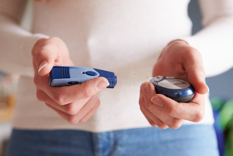 Kvinnlig diabetiker som kontrollerar blod Sugar Levels royaltyfri bild Kvinnlig diabetiker som kontrollerar blod Sugar Levels royaltyfri bild