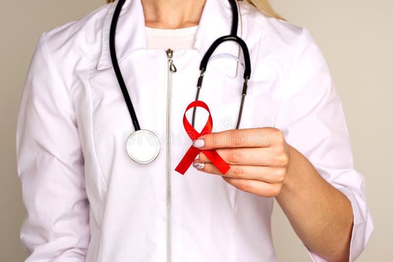 Kvinnlig doktor med HJÄLPMEDLET, rött band för HIV Cancerbegrepp Doktor Holds Red Ribbon till medvetenhetv?rlden bist?r dagen Dec arkivfoton Kvinnlig doktor med HJÄLPMEDLET, rött band för HIV Cancerbegrepp Doktor Holds Red Ribbon till medvetenhetv?rlden bist?r dagen Dec arkivfoton