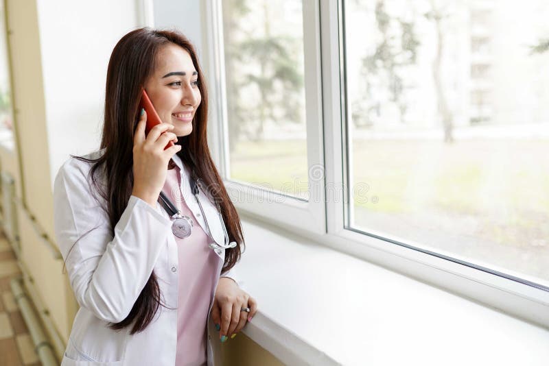 Kvinnlig doktor med mobiltelefonen p royaltyfria bilder Kvinnlig doktor med mobiltelefonen p royaltyfria bilder