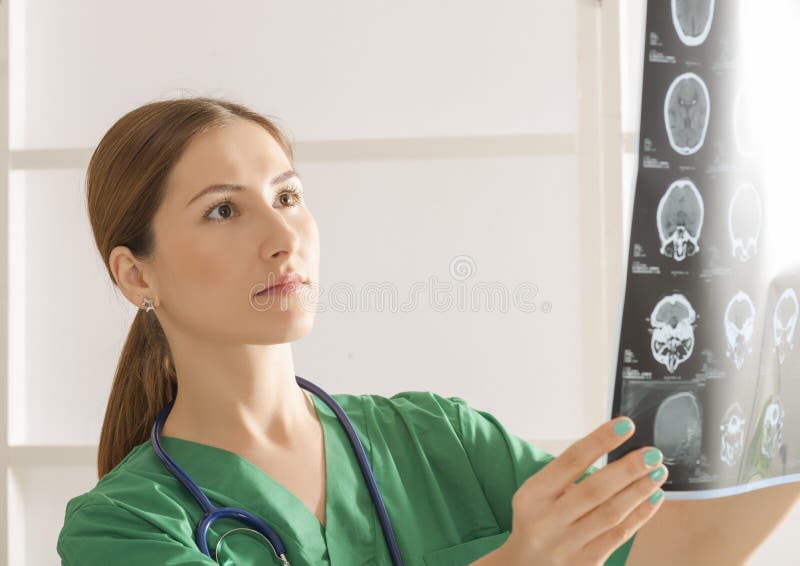 Kvinnlig doktor som ser hjärntomography arkivfoto Kvinnlig doktor som ser hjärntomography arkivfoto