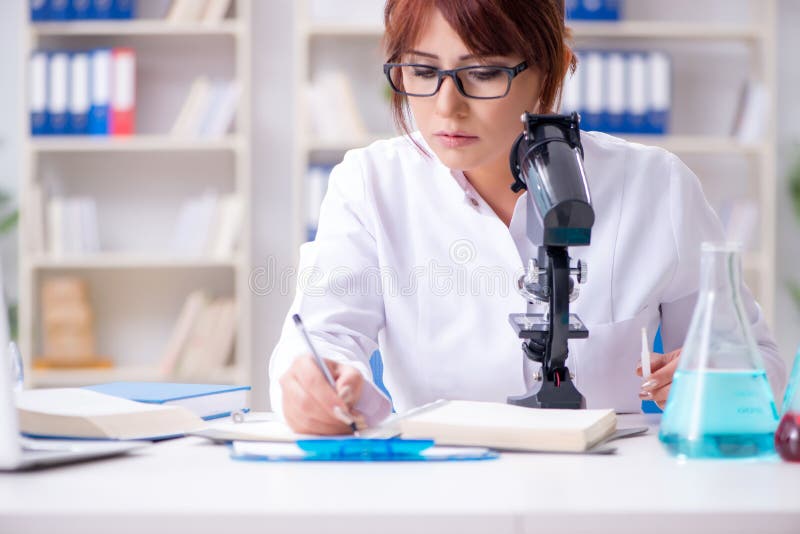 Kvinnlig forskareforskare som för ett experiment i ett laboratorium