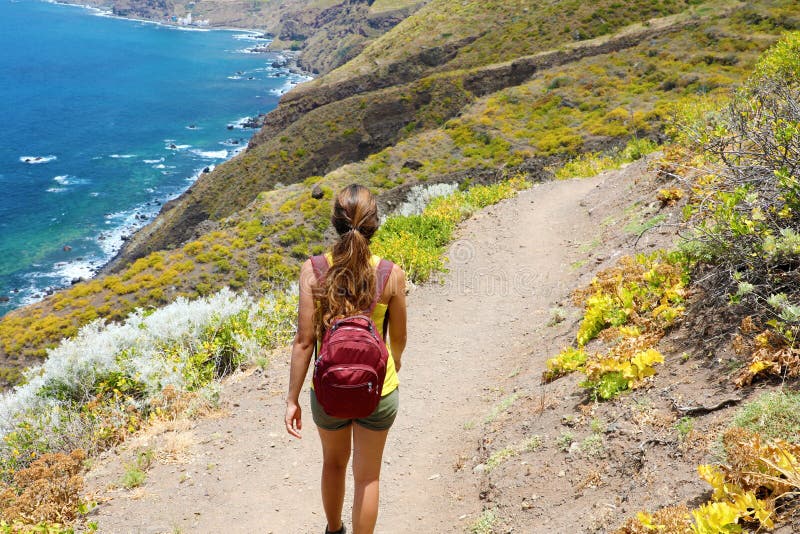 Kvinnlig fotvandrarenedstigning banan med spektakulärt landskap av Tenerife, kanariefågelöar royaltyfria bilder Kvinnlig fotvandrarenedstigning banan med spektakulärt landskap av Tenerife, kanariefågelöar royaltyfria bilder
