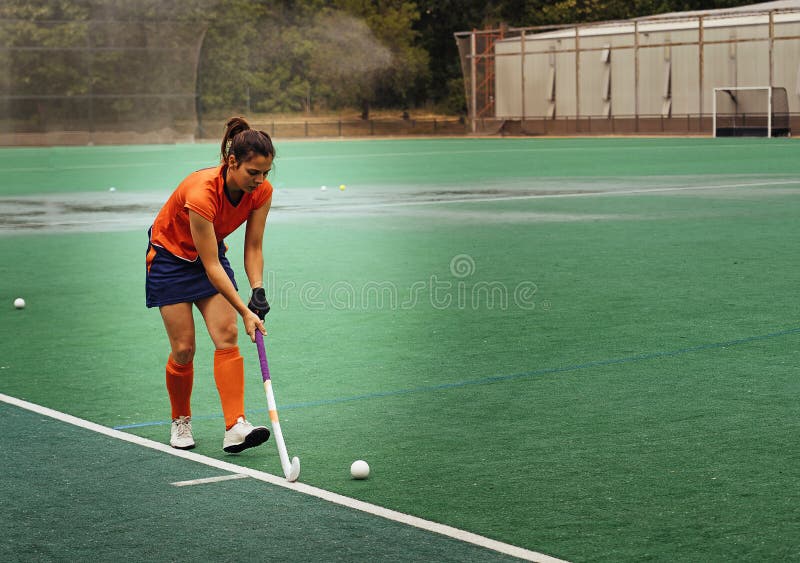 Kvinnlig hockeyspelare som tränar på gräsfält fotografering för bildbyråer Kvinnlig hockeyspelare som tränar på gräsfält fotografering för bildbyråer