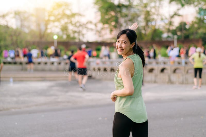 Kvinnlig joggare. en ung kvinna med grön sportkläder och flygplansdans i parken och med friska utomhusaktiviteter. duglighet arkivbild