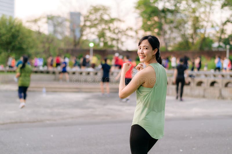 Kvinnlig joggare. en ung kvinna med grön sportkläder och flygplansdans i parken och med friska utomhusaktiviteter. duglighet royaltyfri foto