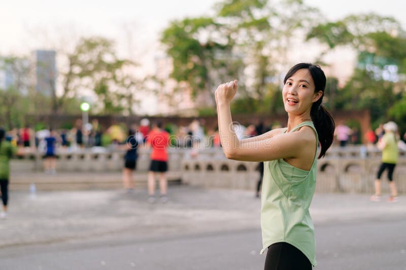 Kvinnlig joggare. en ung kvinna med grön sportkläder och flygplansdans i parken och med friska utomhusaktiviteter. duglighet fotografering för bildbyråer