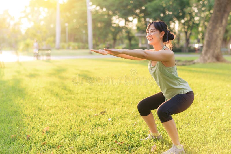 Kvinnlig joggare. lämplig ung asiatisk kvinna med grön sportklädesplagg i parken innan hon springer och njuter av en frisk utomhus royaltyfria foton