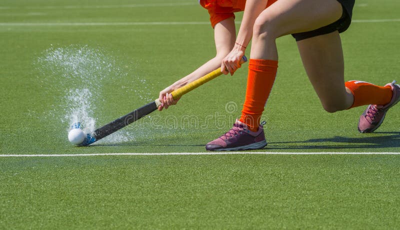 Kvinnlig landhockeyspelare som passerar till en lagkompis p? ett modernt, konstgjort astroturff?lt f?r vatten arkivbilder Kvinnlig landhockeyspelare som passerar till en lagkompis p? ett modernt, konstgjort astroturff?lt f?r vatten arkivbilder