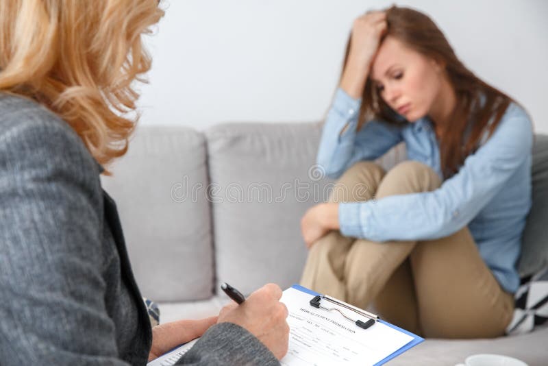 Kvinnlig psychologystterapiperiod med klienten som sitter inomhus fullgöra den medicinska formen arkivfoton Kvinnlig psychologystterapiperiod med klienten som sitter inomhus fullgöra den medicinska formen arkivfoton