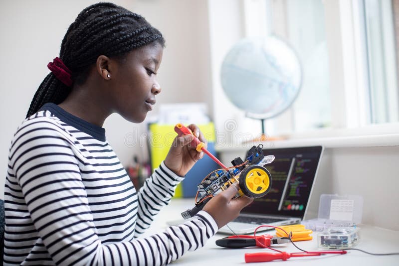 Female Teenage Pupil Builds Robot Car In Science Lesson. Female Teenage Pupil Builds Robot Car In Science Lesson