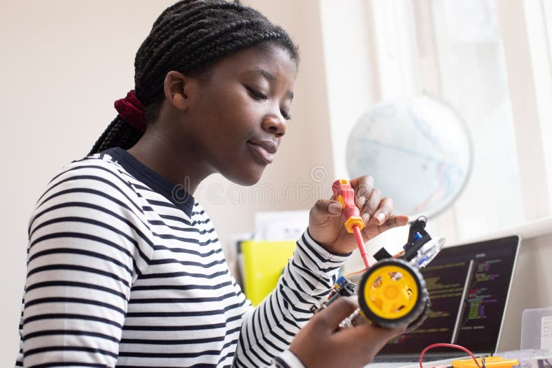 Female Teenage Pupil Builds Robot Car In Science Lesson. Female Teenage Pupil Builds Robot Car In Science Lesson