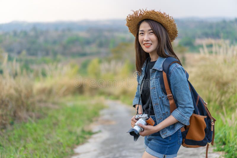 Kvinnlig turist med ryggsäcken och kamera i bygd fotografering för bildbyråer Kvinnlig turist med ryggsäcken och kamera i bygd fotografering för bildbyråer