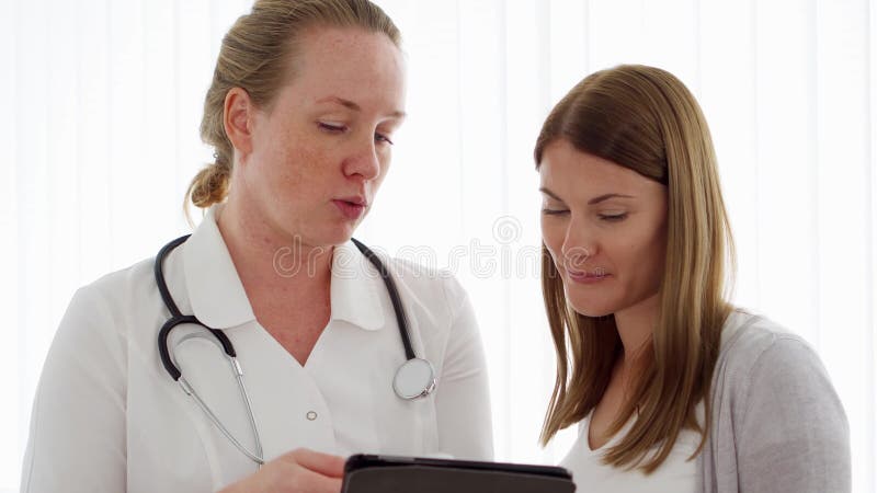 Kvinnlig yrkesmässig doktor på arbete Kvinnaläkare med den konsulterande patienten för stetoskop i klinik