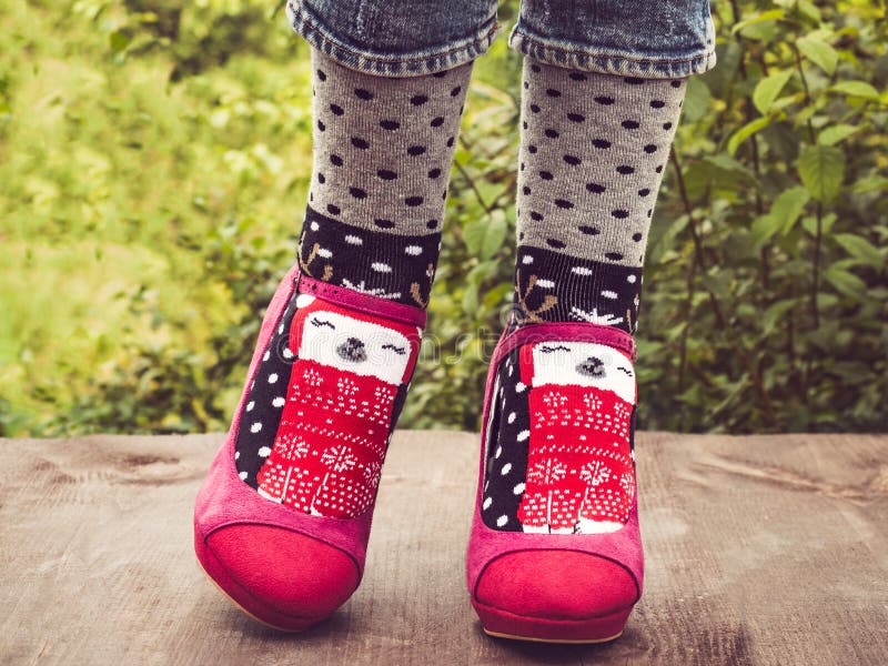Kvinnliga ben i stilfulla rosa skor och ljusa sockor arkivfoto Kvinnliga ben i stilfulla rosa skor och ljusa sockor arkivfoto