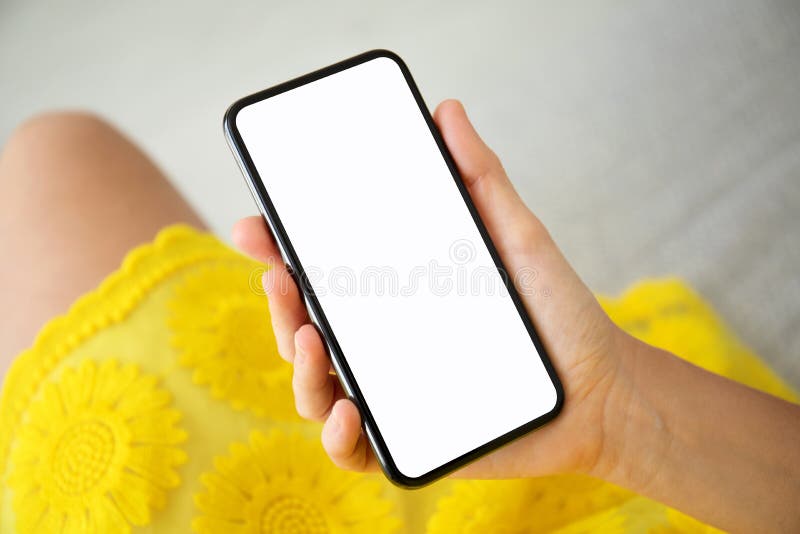 Kvinnliga händer i gul klänninginnehavtelefon med den isolerade skärmen royaltyfri foto Kvinnliga händer i gul klänninginnehavtelefon med den isolerade skärmen royaltyfri foto