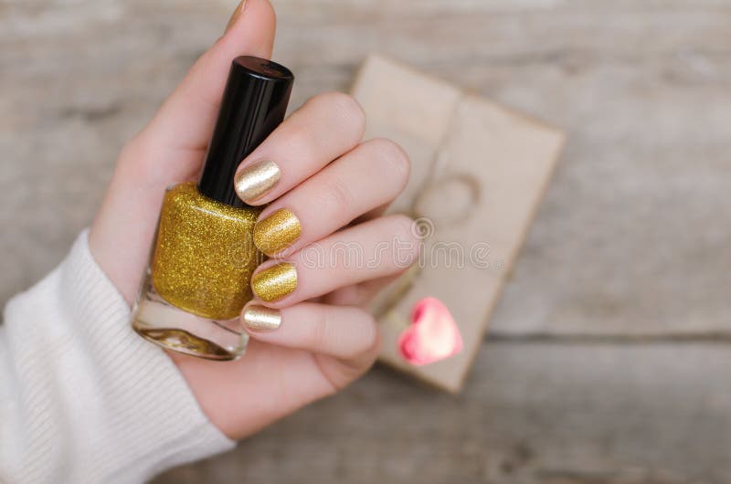 Kvinnliga händer med guld spikar design arkivbilder Kvinnliga händer med guld spikar design arkivbilder