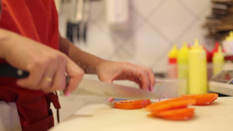 Kvinnlighandkocken klippte nya grönsaker och dill