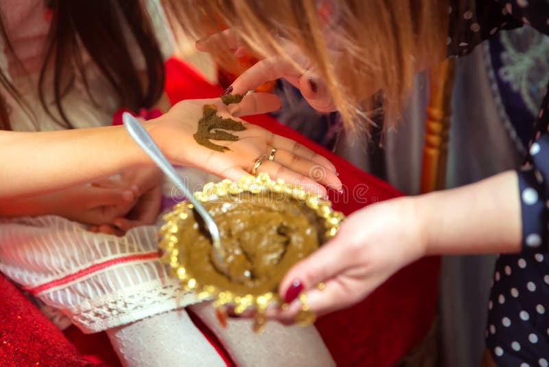 Kvinnlighänder färgade dekorativt vid henna med koppen Rym en bunke med kokosnöten under henne händer Blandande henna för hår Nat royaltyfri foto Kvinnlighänder färgade dekorativt vid henna med koppen Rym en bunke med kokosnöten under henne händer Blandande henna för hår Nat royaltyfri foto