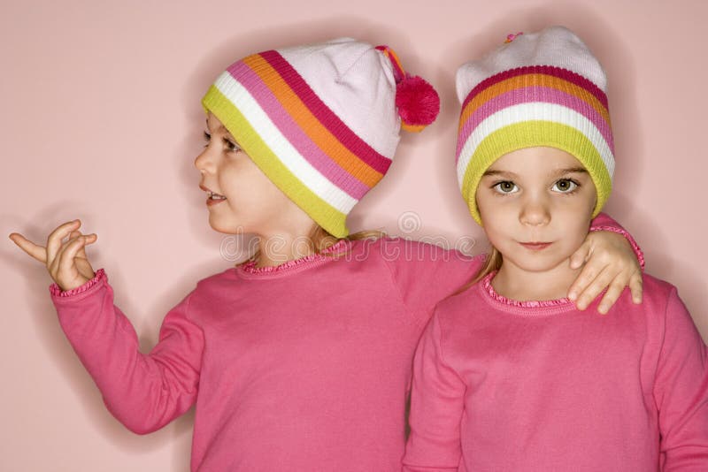 Young female twin Caucasian children standing together. Young female twin Caucasian children standing together.