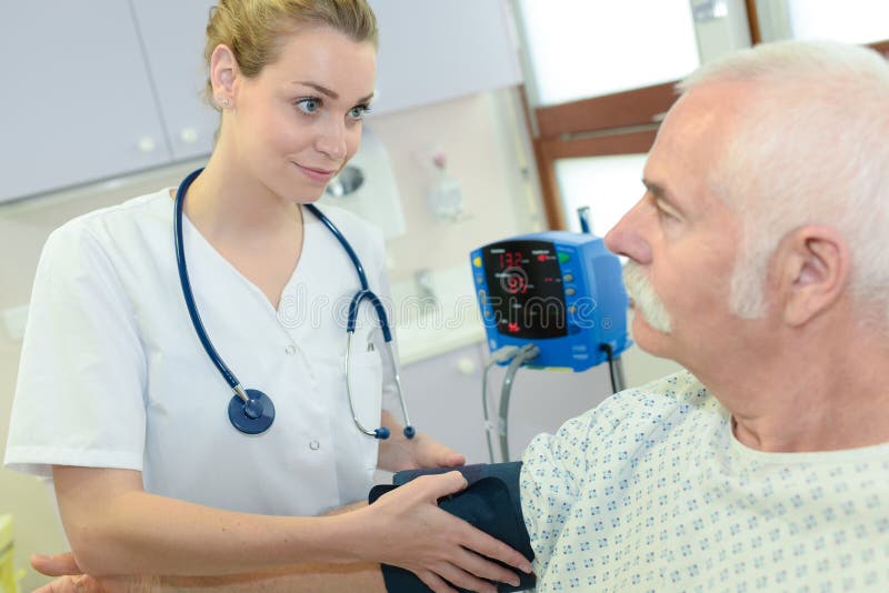 Kvinnligt doktorsprovningsblodtryck till den höga patienten royaltyfria foton Kvinnligt doktorsprovningsblodtryck till den höga patienten royaltyfria foton