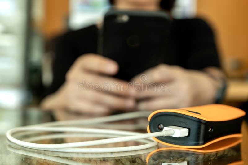 Women are using a power bank for smart phone charging. Women are using a power bank for smart phone charging.