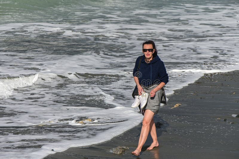 woman walks barefoot along the Mediterranean Sea in Cyprus in winter 2023 9. woman walks barefoot along the Mediterranean Sea in Cyprus in winter 2023 9