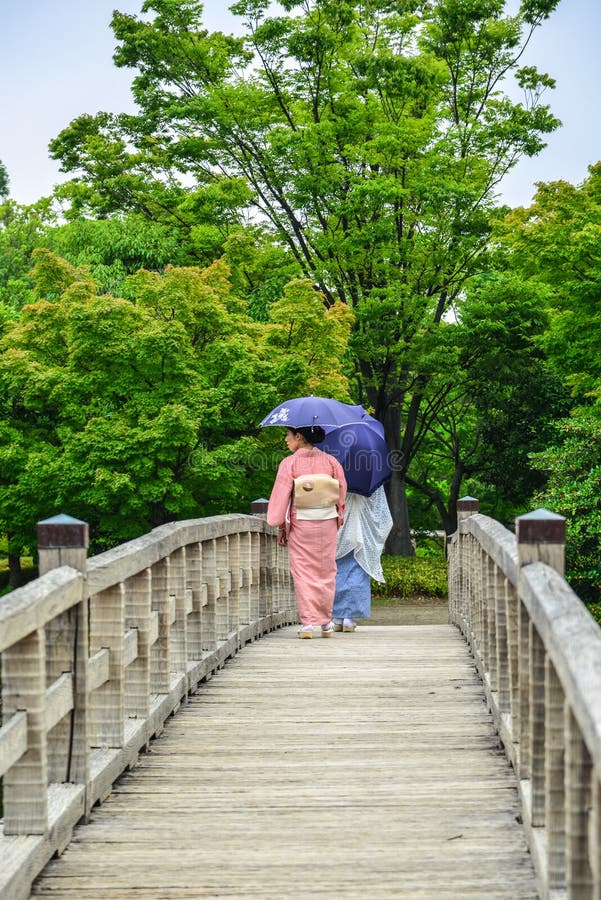 Kvinnor i kimono som går på träbron royaltyfria bilder Kvinnor i kimono som går på träbron royaltyfria bilder