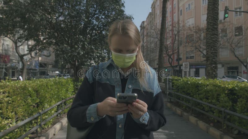 Kvinnor i maskopi som går på gatan lockas till mobil arkivfilmer